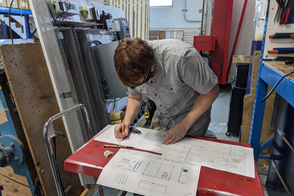 Engineer working on spec sheets Reviewing one-line plans